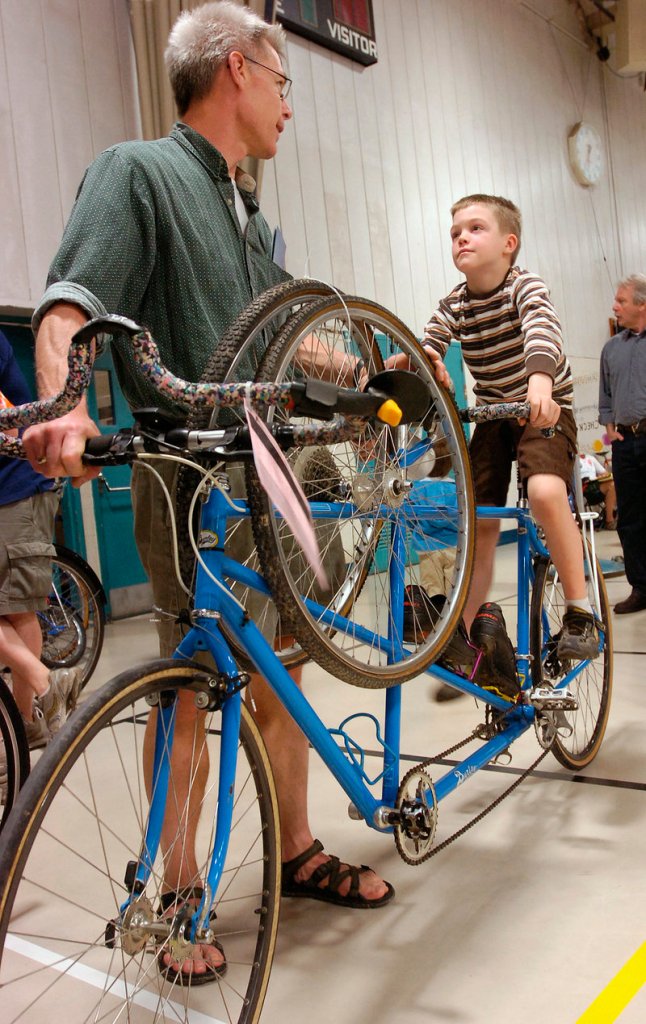 David Waggoner and his son Sam, 7, of Gorham, wait in line to purchase a tandem bike.