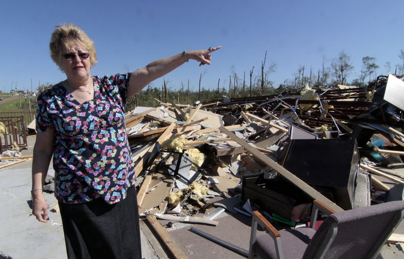 Hillcrest Baptist Church member Carolyn Porter stands amid the rubble of the Yazoo City, Miss., structure on Sunday. Porter and other members held a brief morning service before searching through the debris for Bibles, hymnals and other church-related materials. The church was destroyed by one of several tornados that blew through the state on Saturday.
