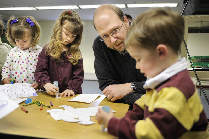 Reporter Ray Routhier helps Patrick Downey, 2, work on a craft project at Baxter Memorial Library in Gorham. At left are Michelle Meecham and Patrick's sister, Madeline, both 4.