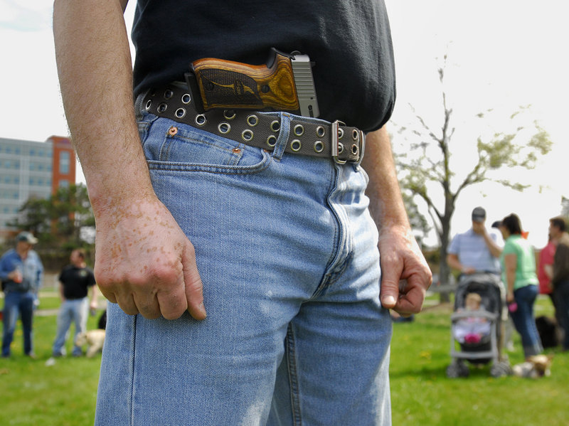 A pro-gun demonstrator who did not want to be identified stands in a park at Back Cove in Portland during an open-carry gathering on Sunday.