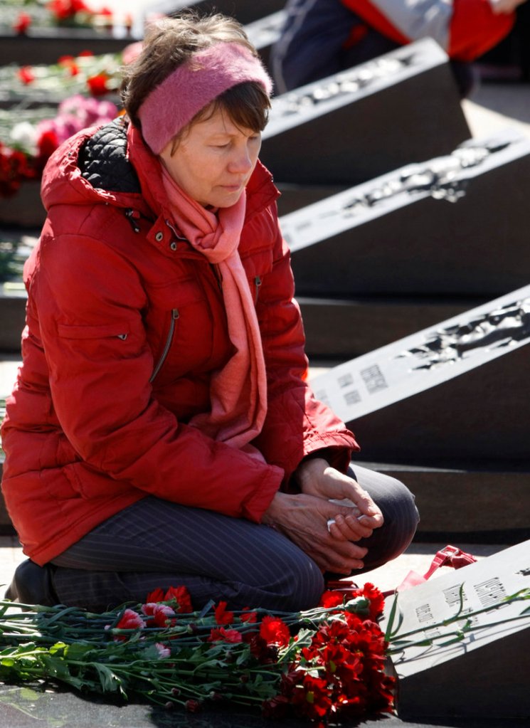 A relative of Klavdia Luzganova, who died when a reactor at the Chernobyl nuclear plant exploded on April 26, 1986, mourns over her grave Monday at Mitino cemetery in Moscow. Health groups estimate that radiation from the explosion has caused more than 700,000 premature deaths.
