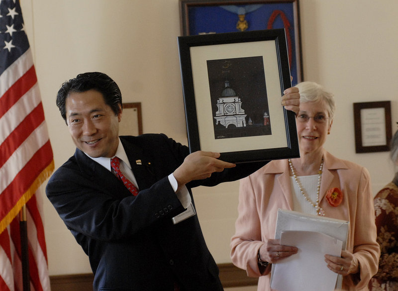 Takenobu Honda, chairman of the Shinagawa Assembly, shows off a painting of Portland’s City Hall presented to his city. Watching is former Portland Mayor Ann Pringle.
