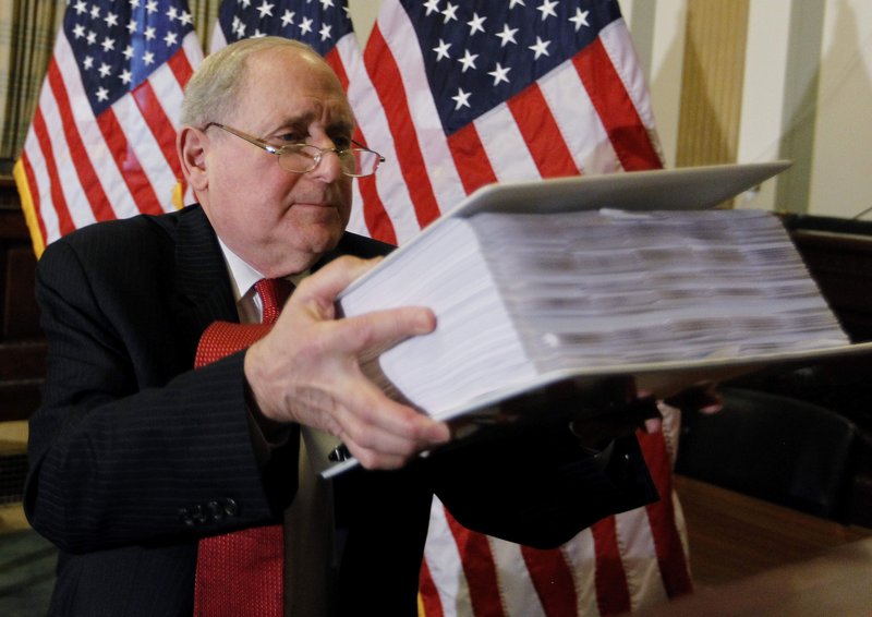 Sen. Carl Levin, D-Mich., chairman of the Senate Investigations Subcommittee, shows documents on the role of investment banks in the Wall Street financial crisis as he briefs reporters on Monday in Washington before today’s testimony by Goldman Sachs executives at a hearing.