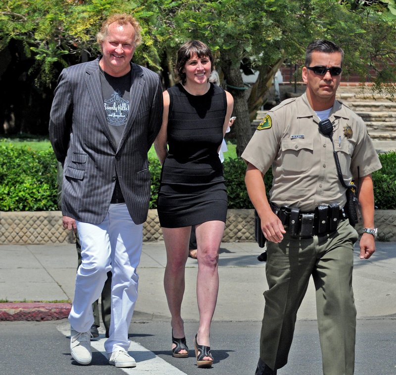Actor Randy Quaid and his wife, Evi, are escorted into court Monday in Santa Barbara, Calif. They were arrested on outstanding warrants.