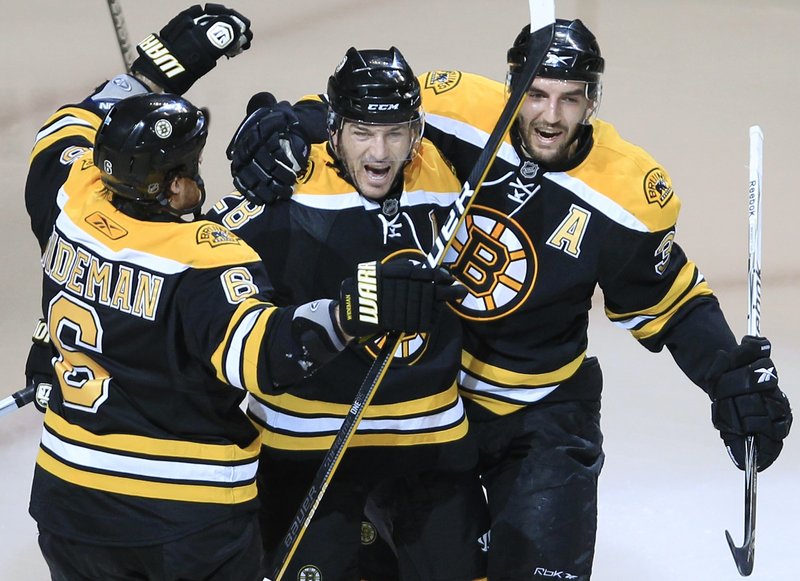Mark Recchi is the center of attention as he receives congratulatons from Dennis Wideman, left, and Patrice Bergeron after his goal in Boston’s 4-3 win over Buffalo.