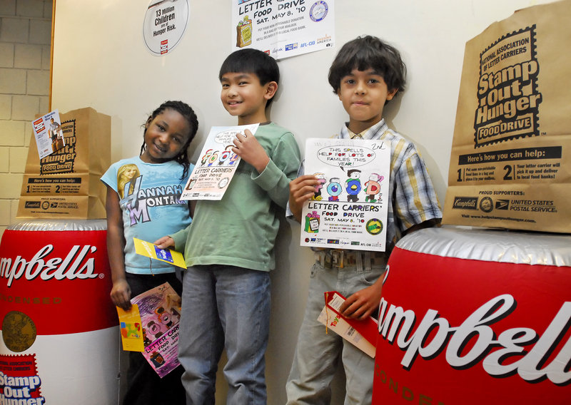 Riverton Community School students Jayda Ray-James, left, Rafael Espineli and Ahmad Qasem hold up their artwork at the school this week. The three young students garnered awards for their entries in a coloring contest sponsored by postal workers to promote the 18th annual Stamp Out Hunger food drive to be held on Saturday, May 8. Rafael and Ahmad, who are second graders, won first and second place respectively, while Jayda, a first grader, earned a third-place award.