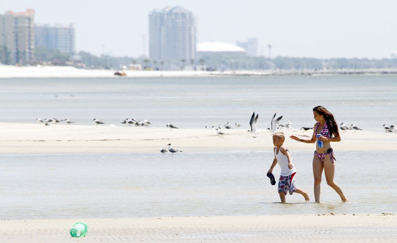Damien Theriot, 6, left, and his mother Rachel Hebert, both of New Orleans, La., enjoy the pristine white sands of the beach in Gulfport, Miss., on Tuesday.