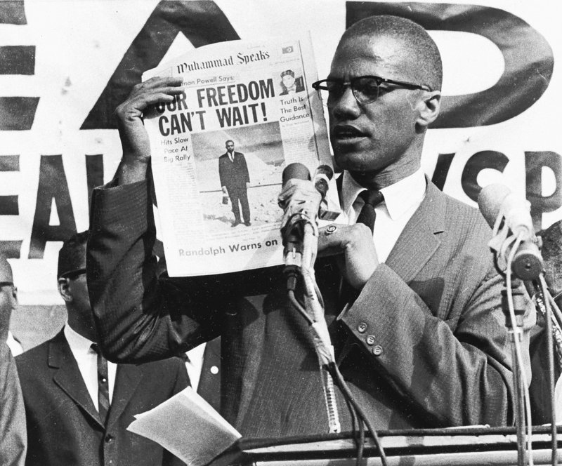 Black Muslim leader Malcolm X holds up a paper for the crowd to see during a Black Muslim rally in New York City on Aug. 6, 1963. One of his killers says Malcolm X was killed in 1965 out of anger at his split with the leadership of the Nation of Islam, the black Muslim movement for which he had once served as a prominent spokesman. Thomas Hagan says he has come to regret his role in the killing.