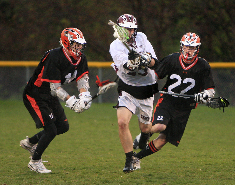 Austin Spencer of Greely, center, heads down the field Tuesday night between Dylan Seeley, left, and Tim Millett of North Yarmouth Academy during NYA's 10-7 victory. Each team has a 1-1 record in boys' lacrosse.
