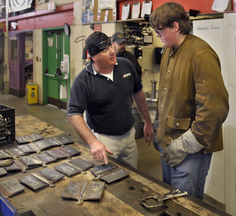 Teacher Bill Presby talks with Ben Martin of Limington concerning his welding test.