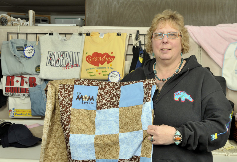 Candy Macomber, owner and operator of Passionate Stitches in Scarborough, shows embroidery she created on a customer’s quilt – a feature she says a larger business does not offer. Her business niche is in making small orders for customers, but she can also do large orders on her $16,000 Tajima sewing machine.