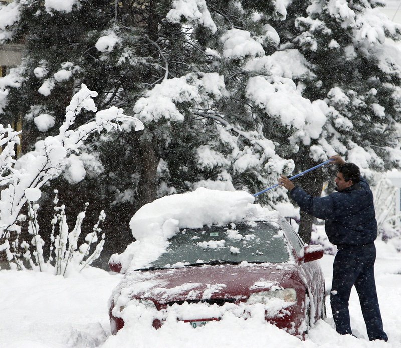 Perez Rios clears his car of snow Wednesday in Littleton, N.H. About 30,000 customers across northern New England and New York were without power at the peak of the storm