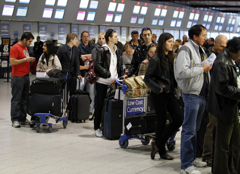 Passengers queue up in the departures area at Luton Airport in Luton, England, after Britain's Civil Aviation Authority said non-emergency flights would be banned in all airports until at least 1 a.m. Friday. Tens of thousands of passengers are stranded across Europe in one of most disruptive events to hit air travel in years.