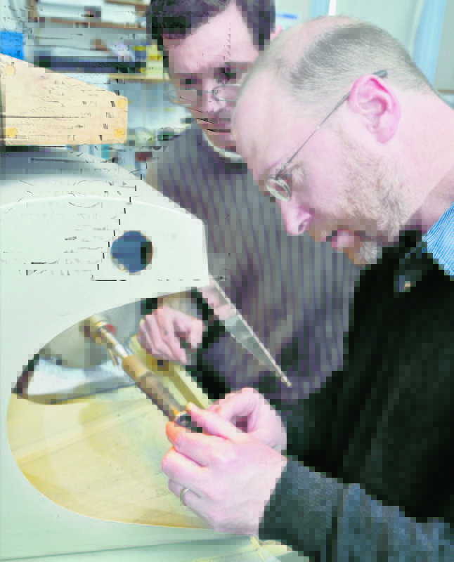 Goldsmith Deane Frank, left, instructs Ray Routhier on the correct way to polish the inside of a ring as he makes a wedding band at Brown Goldsmiths in Freeport.