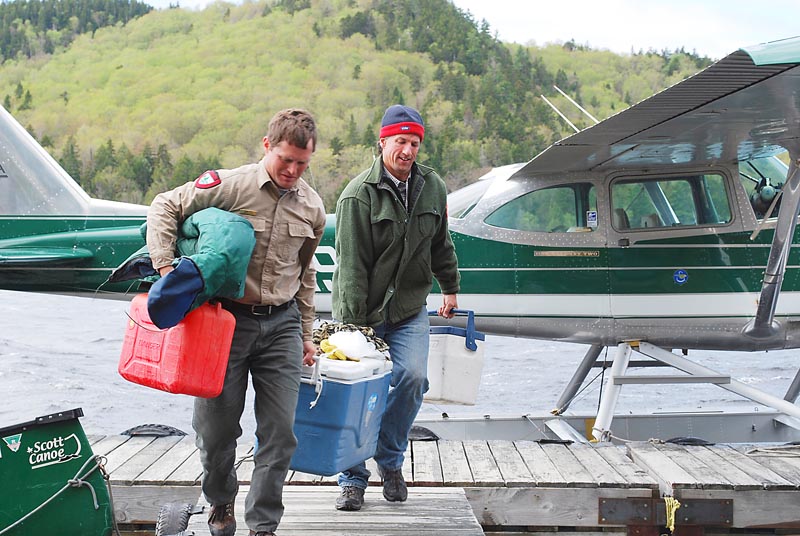 Fisheries biologist Frank Frost and pilot Igor Sikorsky carry an Arctic char caught in Big Reed Pond. The Sikorskys have provided transportation and lodging to char restoration efforts.