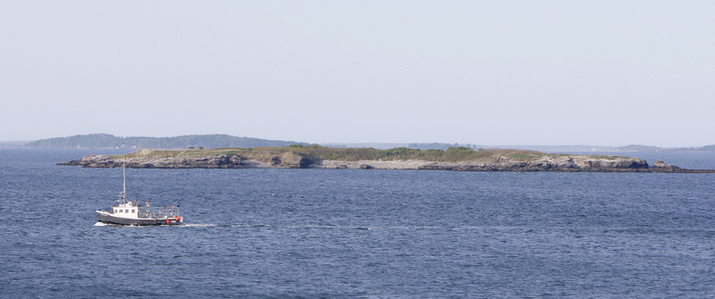 A fishing boat passes by Ram Island in Casco Bay on Monday. Ram Island was the destination of Irina McEntee and Carissa Ireland while kayaking on Sunday. It was the last place they were seen alive by a caretaker on a nearby island and McEntee's parents, who could see from Peaks Island that the girls had made it to the island.