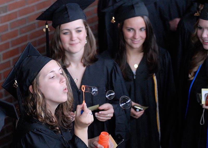University of New England Graduate Margaret Thomas blows bubbles as she waits to enter the Cumberland County Civic Center for Commencement today.