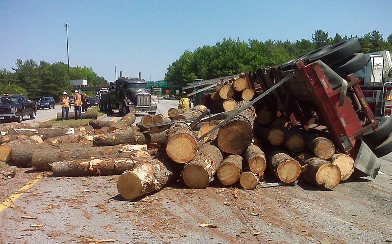 Huge saw logs cover the access road connecting Route 1 to Interstate 295 and the Maine Turnpike in South Portland after a truck and trailer tipped over on an I-295 exit ramp Monday afternoon. The truck driver “was going way too fast for the ramp,” said Maine State Police Trooper Charles Granger. No one was injured.
