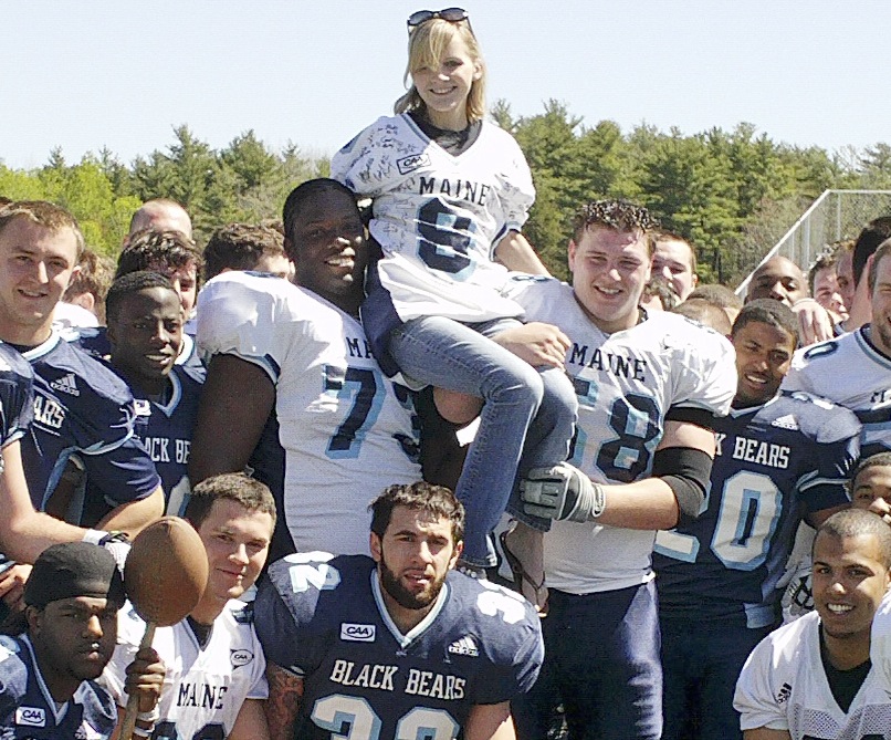University of Maine photo Ashley Drew of Scarborough, a UMaine graduate student and passionate trumpet player, gets a lift from Tyler Patterson, left, and Steve Shea on Saturday after the annual spring football game. The team helped raise money for Drew’s double lung transplant, which she needs because she suffers from cystic fibrosis.