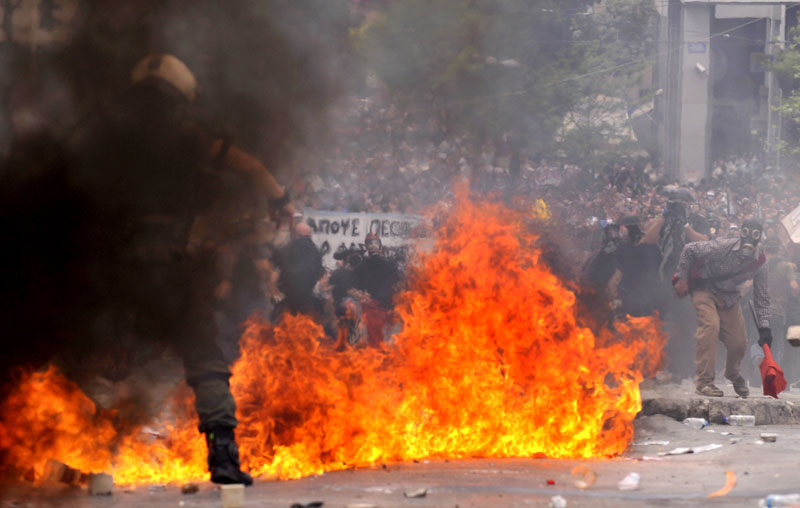 Riot police clash with demonstrators in central Athens today. Greek fire officials say three people died in a blaze that broke out at an Athens bank during rioting over government austerity measures. Angry protesters also tried to storm parliament, hurled Molotov cocktails at police and torched buildings.