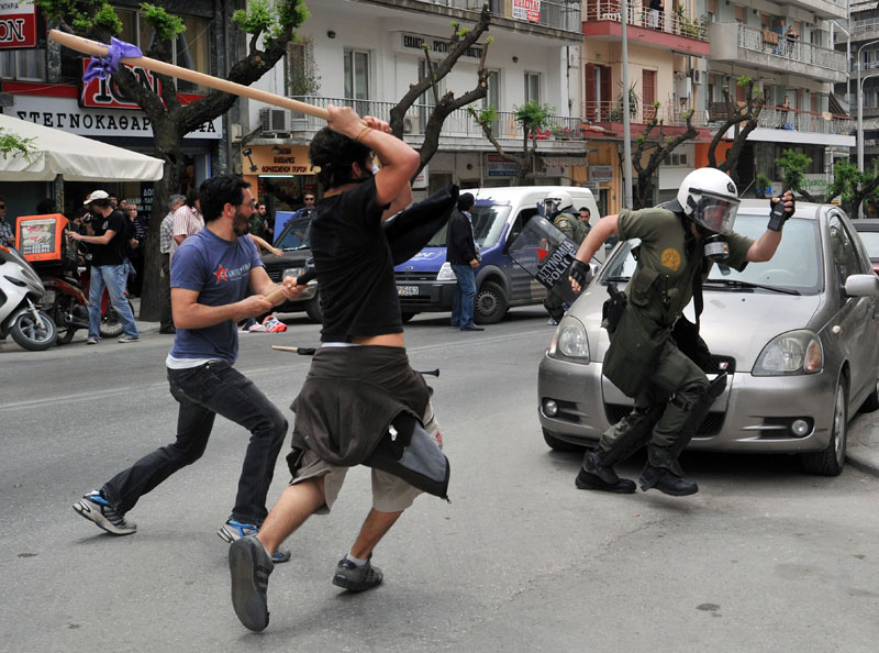 A riot policeman runs from angry protesters in the northern Greek port city of Thessaloniki today.