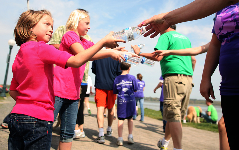 Kayla Rairdon, 6, left, and her sister Hannah, 9, of Westbrook hand out water to walkers at a water station along the Back Cove during the March of Dimes March for Babies in Portland on Sunday.