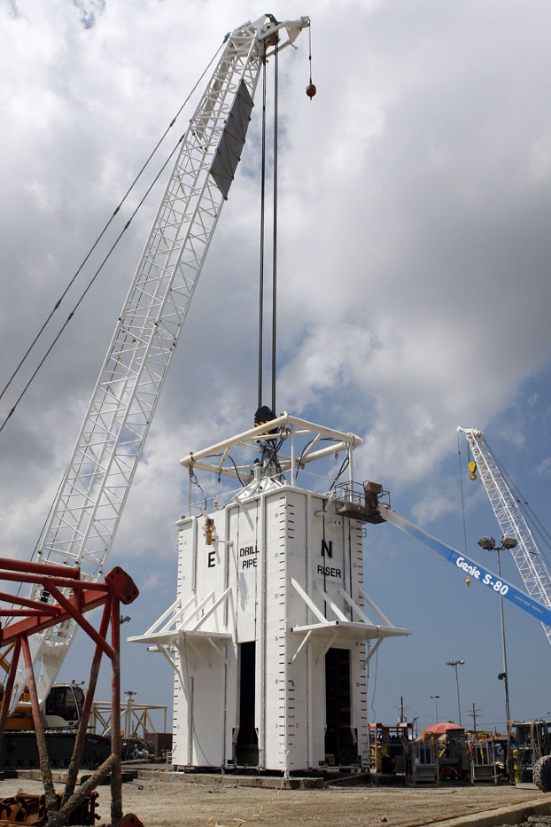 A crane prepares to lift a chamber that will be used to help contain oil leaking from the Deepwater Horizon oil drilling platform onto a barge in Port Fourchon, La., today.