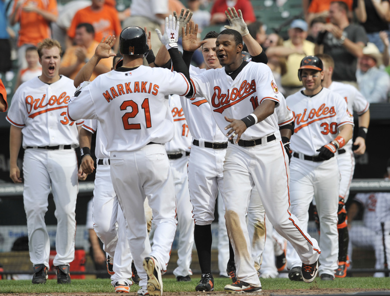 The Associated Press Nick Markakis of the Orioles is greeted at home after scoring the winning run in a 3-2 decision over the Red Sox in 10 innings Sunday. It’s Baltimore’s first home three-game sweep of Boston in 36 years.