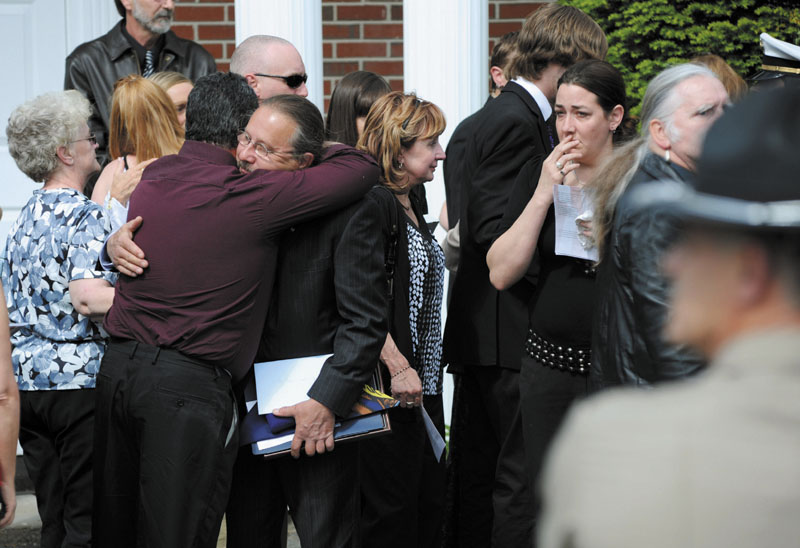 Army Spc. Wade Slack's father, Dr. Alan Slack, holds federal and state honors awarded to his son as he is greeted by family and friends following the funeral Sunday at Blessed Hope Advent Christian Church in Waterville. Wade Slack, 21, specialized in disarming explosives and died of wounds suffered May 6 in indirect fire in Jaghatu, Afghanistan.