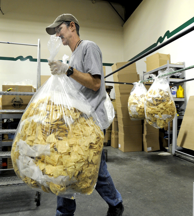 Larry Cook totes a bag of tortilla chips for sorting and bagging at Montecito Roadhouse Inc. in Portland.
