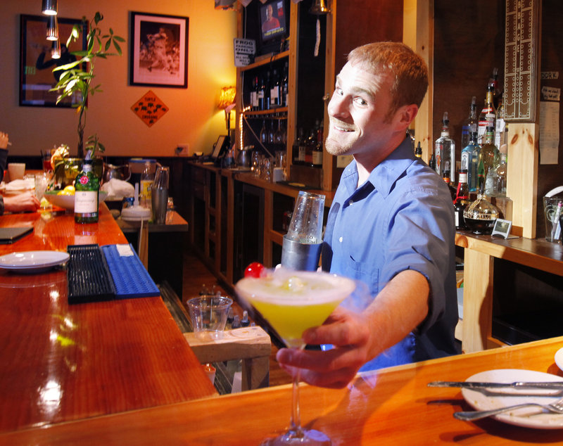 At the Frog & Turtle pub in Westbrook, bartender Evan Walsh displays a Swamp Martini, one of the pub's signature drinks.