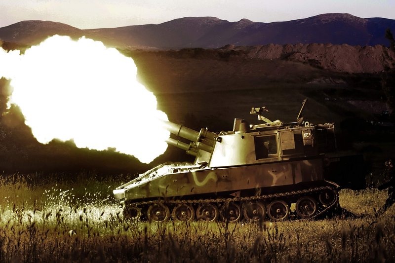 Two self-propelled howitzers fire shells during a training exercise Thursday night in Thiva, Greece. Greece's defense minister promised "colossal" cuts in military operating costs to help the country emerge from its financial crisis and speed plans to modernize the armed forces.