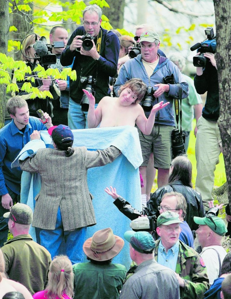 University of Maine at Farmington student Andrea Simoneau shrugs as Elaine Graham shields Simoneau’s breasts during a topless protest Friday in Farmington. The demonstration called attention to a perceived double-standard that makes it acceptable for men, but not women, to be topless in public.