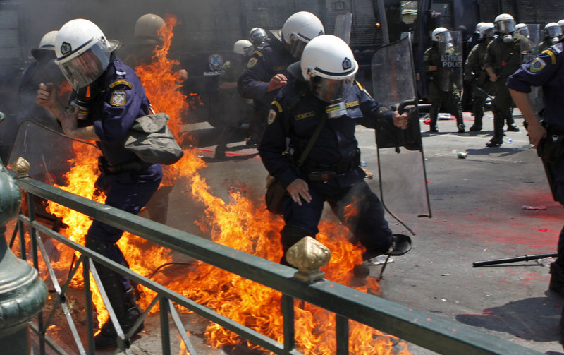 Greek riot police are set on fire by protesters throwing Molotov cocktails in Athens on Saturday. Seven officers and two demonstrators were injured in the rioting.