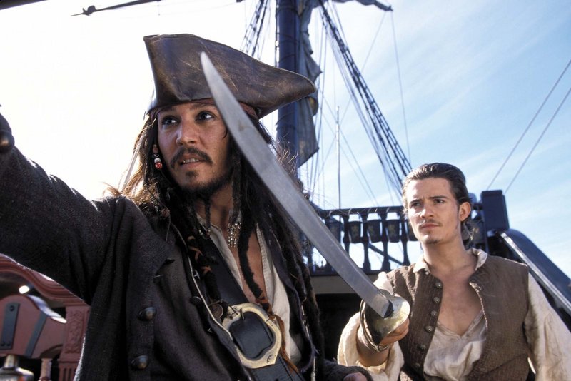 Capt. Jack Sparrow (Johnny Depp, left) and Will Turner (Orlando Bloom, right) are shown in a scene from “Pirates of the Caribbean: The Curse of the Black Pearl.” An 18-year-old woman has pleaded not guilty to breaking into Bloom’s home.