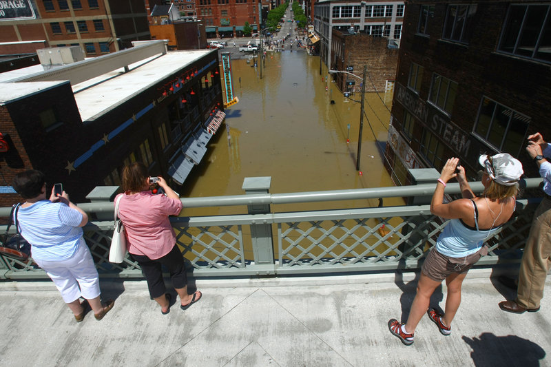 Spectators look at a flooded downtown street from over the Cumberland River on Monday in Nashville. About 1,500 guests were evacuated overnight from the Gaylord Opryland hotel.