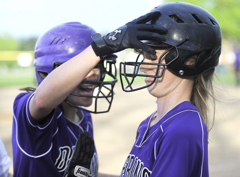 Nicole Mason of Deering gets a pat on the helmet from Jen Lynch after scoring the go-ahead run in the bottom of the sixth inning.
