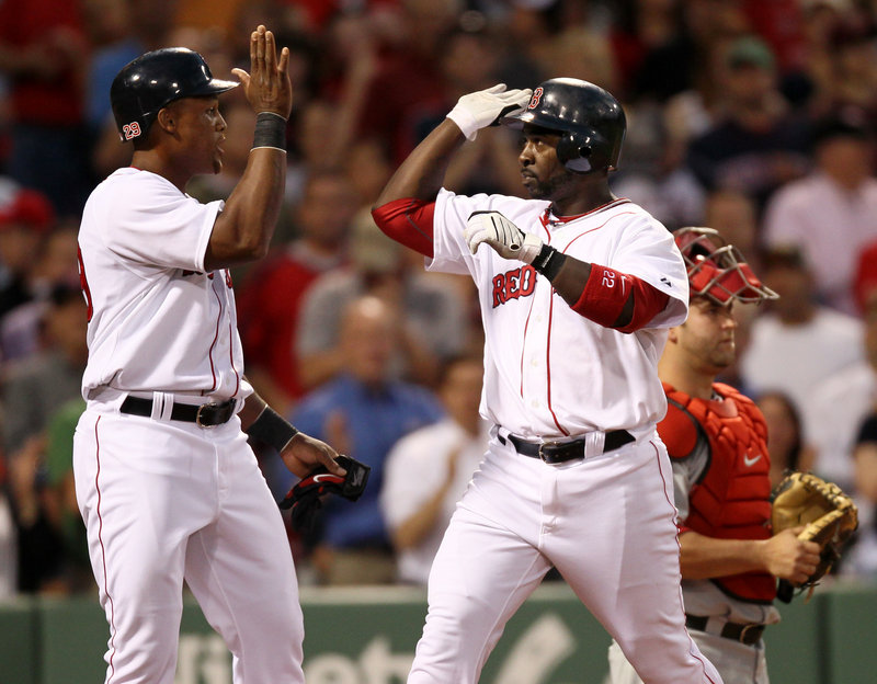 Adrian Beltre, left, greets Red Sox teammate Bill Hall at the plate Monday night after Hall’s two-run homer in the second inning against the Angels at Fenway Park. Boston won, 17-8.