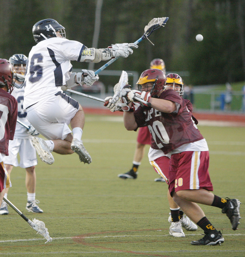 Mike McCormack of Yarmouth leaps into the air to fire a shot over Cape Elizabeth goalie Jack Roos for a second-quarter goal Monday night at Yarmouth. The Clippers won, 8-4.