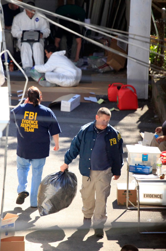 FBI agents remove evidence Tuesday from a house in Bridgeport, Conn. Investigators also served a search warrant at suspect Faisal Shahzad’s home in Shelton, Conn., and visited a gun shop where he bought a rifle in March. Agents found a gun in a car used by Shahzad.
