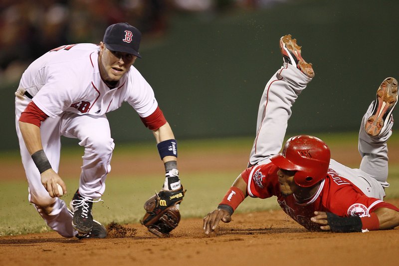 Dustin Pedroia of the Boston Red Sox sets to throw to first to complete a double play after tagging out Erick Aybar of the Los Angeles Angels in the eighth inning Tuesday night – a pivotal play in Boston’s 5-1 victory at Fenway Park.