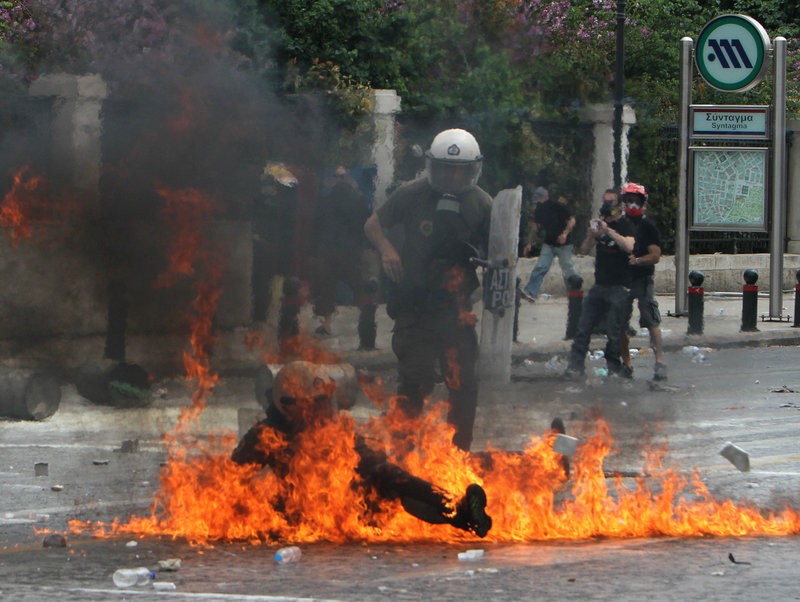 A riot officer is engulfed in flames from a firebomb thrown by protesters Wednesday in Athens. Demonstrators hurled stones at police, who responded with tear gas, as tens of thousands of Greeks took to the streets to protest harsh new cuts aimed at saving their country from bankruptcy.