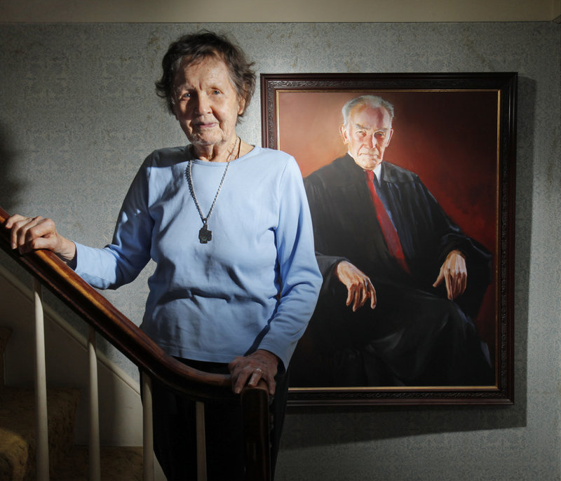 Ruth Coffin poses for a photo in her South Portland home next to a painting of her husband, Judge Frank M. Coffin, a federal appeals court judge who died in December. On Saturday, about 50 judges from around the country are expected to attend a celebration of life for Coffin.