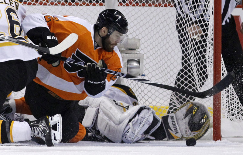 Ville Leino of the Flyers looks for the puck as Bruins goalie Tuukka Rask tries to cover the corner with his glove hand while sprawled in the goal. Rask had 34 saves in Boston’s 4-1 win.