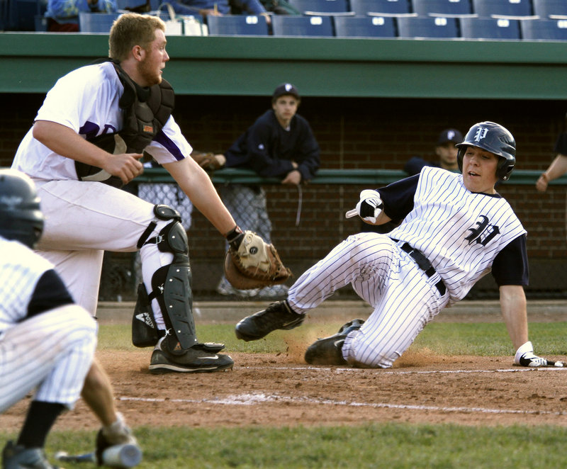 Rudy DiMillo of Portland is tagged out at the plate Thursday by Deering catcher Pat Bride while trying to score in the fifth inning of Portland's 8-7 victory at Hadlock Field. The Bulldogs are 4-1 and dropped Deering to 4-2.