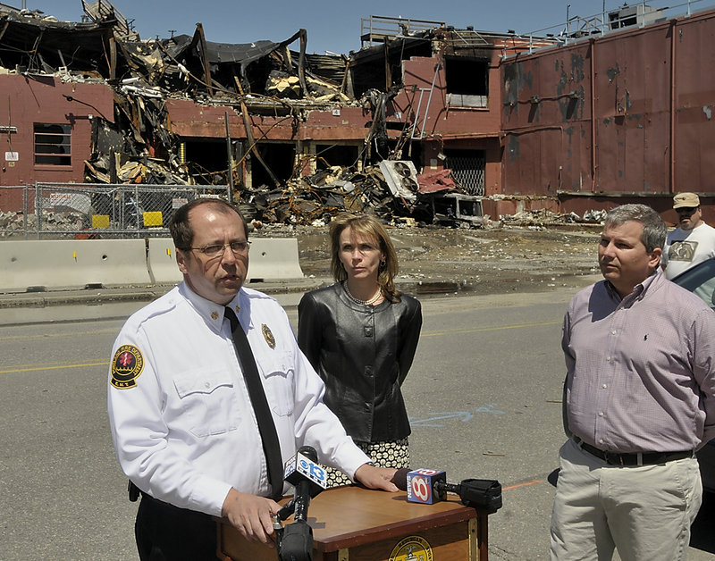 Portland Fire Chief Fred LaMontagne speaks Friday as Planning Director Penny Littell and Mark Woglom, a partner in a hotel and condo project on the old Jordan’s Meats property, await their turn to take questions about Thursday’s fire at the site.