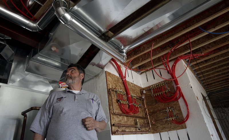 Builder Dave Hamilton explains some of the green aspects, including the geothermal heating and radiant heating systems, being used in the construction of Eva and Daryl Lehman’s new home in southeast Sheboygan County, Wis.
