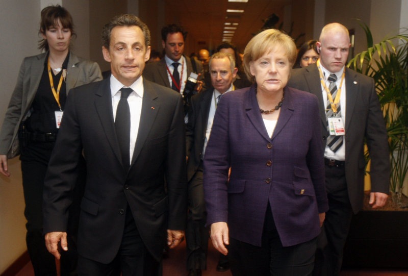 French President Nicolas Sarkozy, second from left, walks with German Chancellor Angela Merkel, second from right, after a meeting on the sidelines of an emergency European Union summit Friday in Brussels.