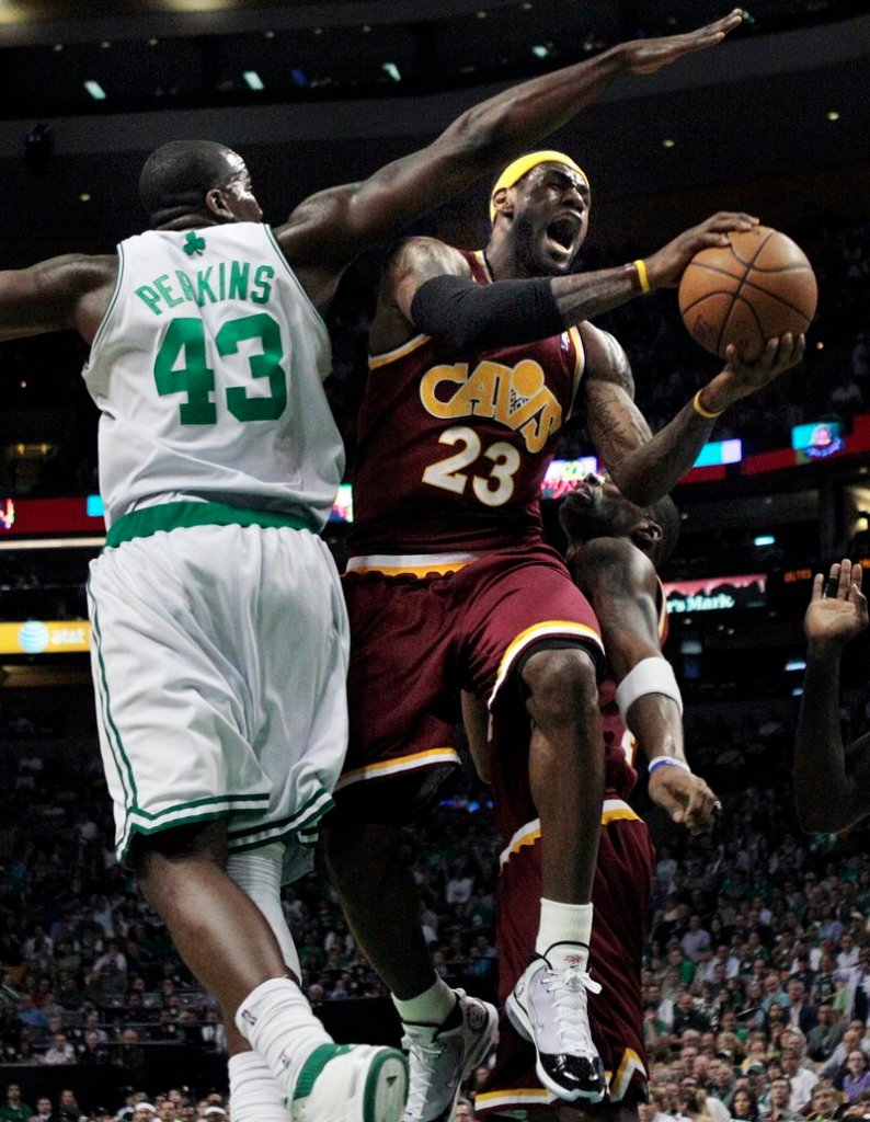 LeBron James of the Cleveland Cavaliers threads his way past Kendrick Perkins of the Boston Celtics to score during his 21-point first quarter Friday night in Boston.