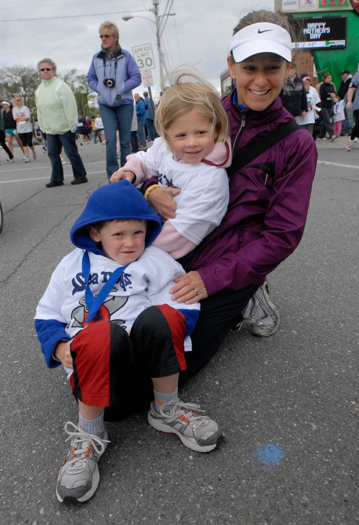 Erika Hemphill of Freeport and her children Oliver, 6, and Natalia, 3, huddle together on the sidelines Sunday in anticipation of the start of the 10th annual Sea Dogs Mother’s Day 5K race.